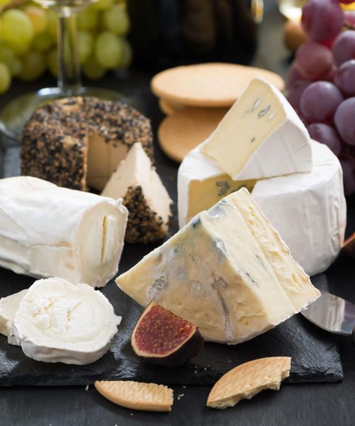 delicacy soft cheeses, fruit and crackers, close-up